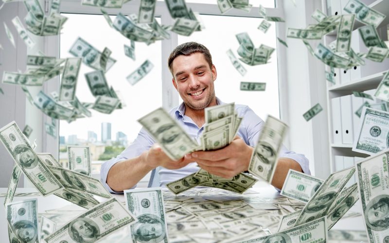 Happy Businessman With Heap Of Money