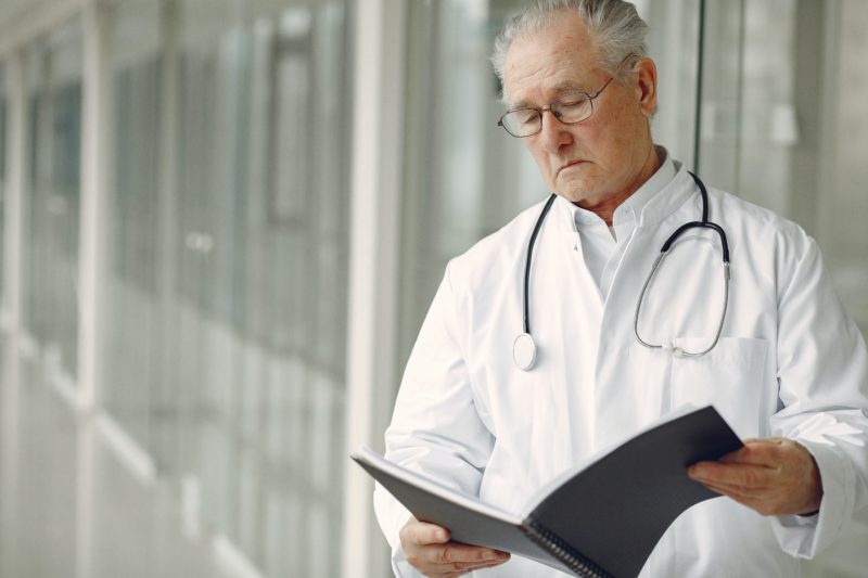contemplative-doctor-in-uniform-reading-clinical-records-4173239