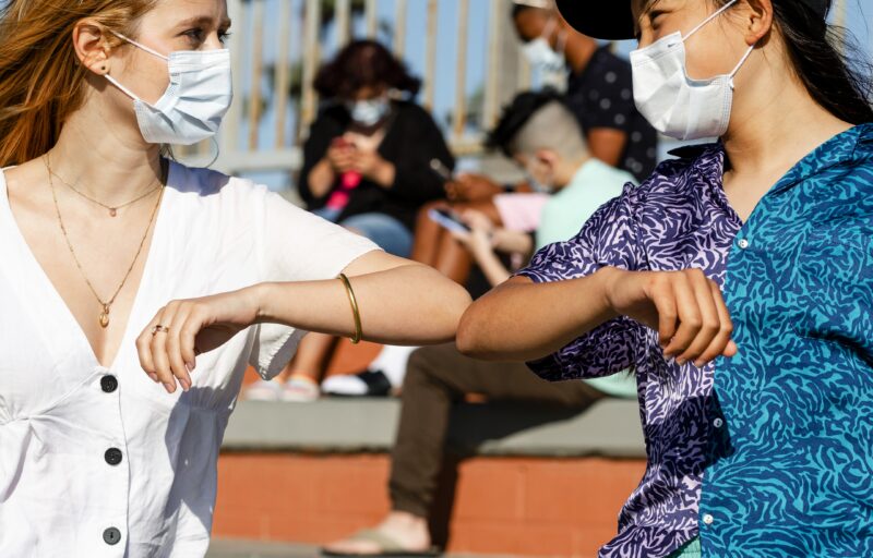 The new normal greeting elbow bump at an outdoors park